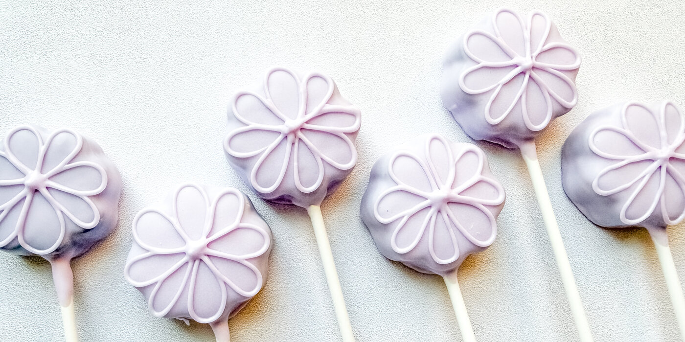Lavender cake pops with piped daisy flower detail