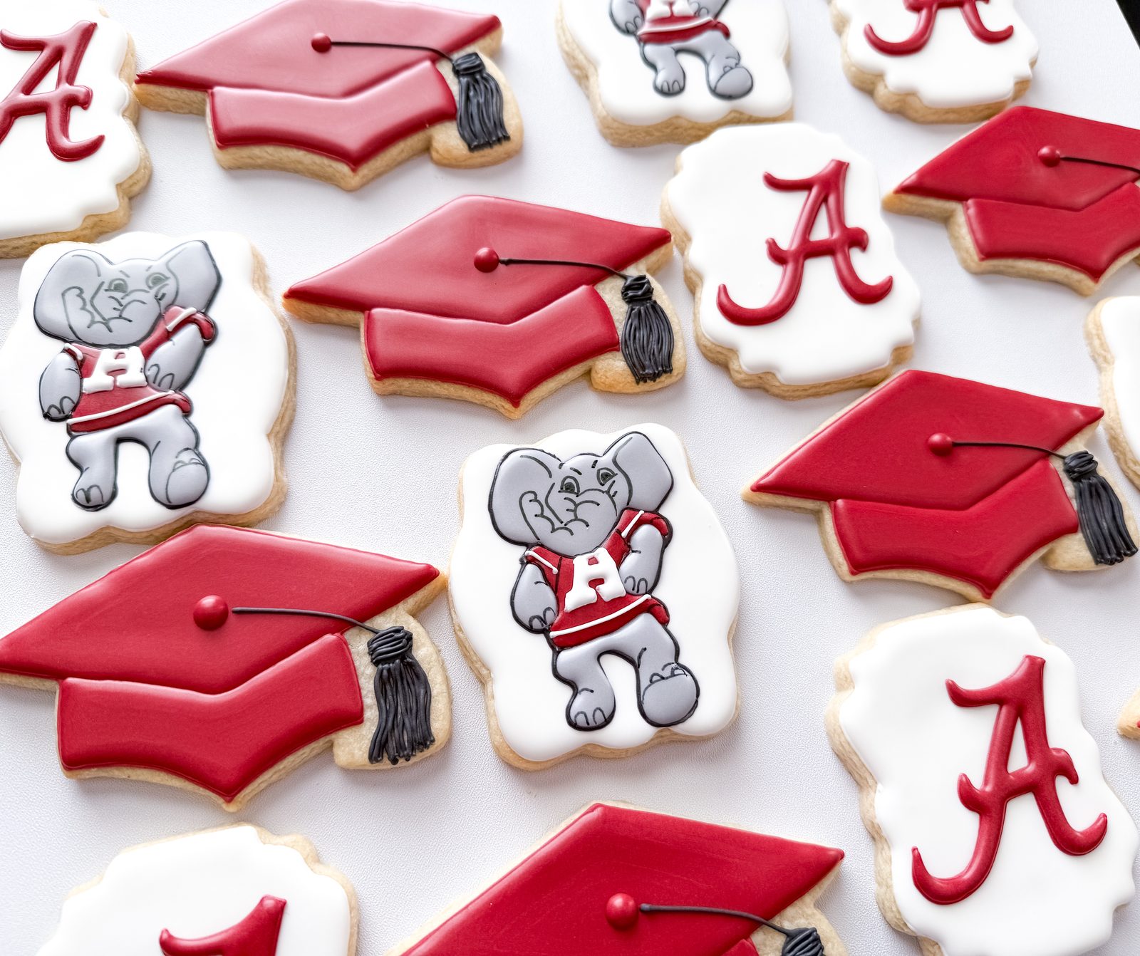 Alabama graduation cookies with Big Al mascot, crimson grad caps, and script A logos