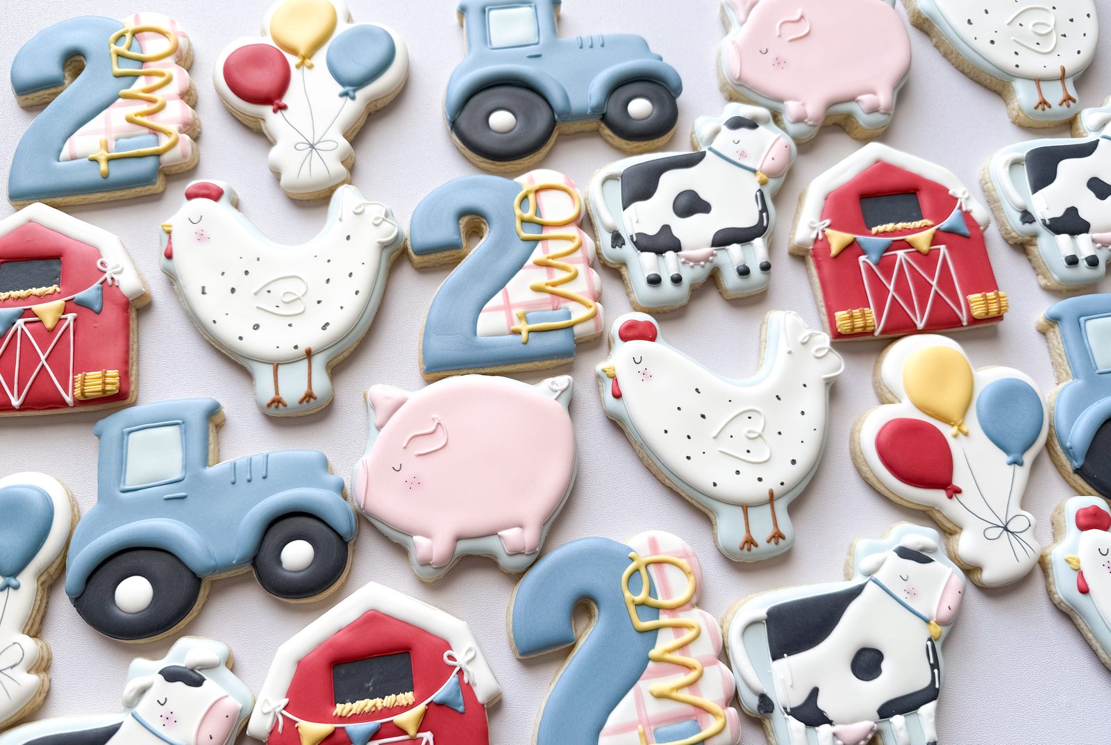 Farm themed second birthday cookies with tractors, barns, cows, pigs, and chickens