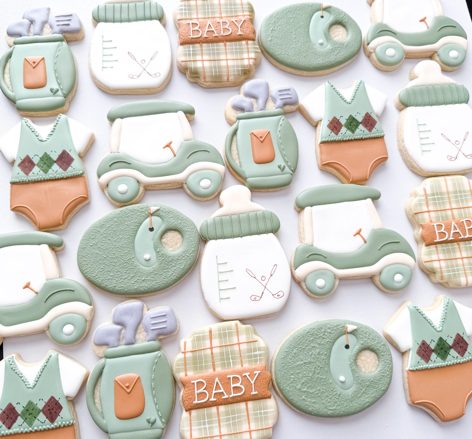 Golf themed baby shower cookies with argyle onesies, golf carts, club bags, and plaid