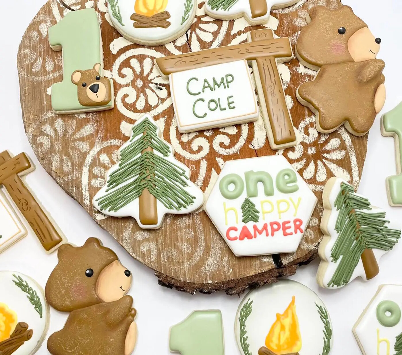 One Happy Camper first birthday cookies with bears, pine trees, campfires, and a custom camp sign