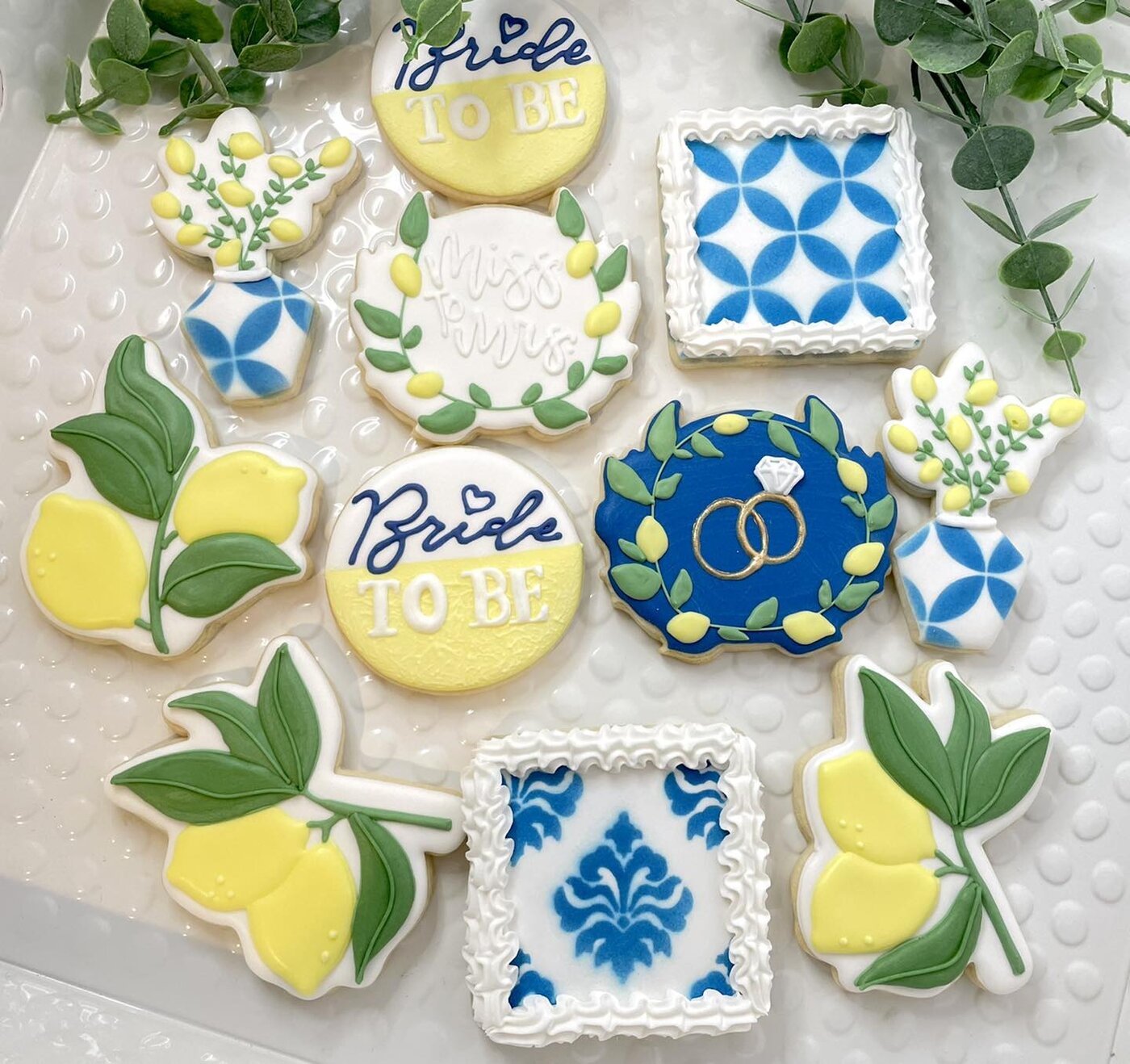 Lemon and blue tile bridal shower cookies with Bride to Be plaques and gold wedding rings