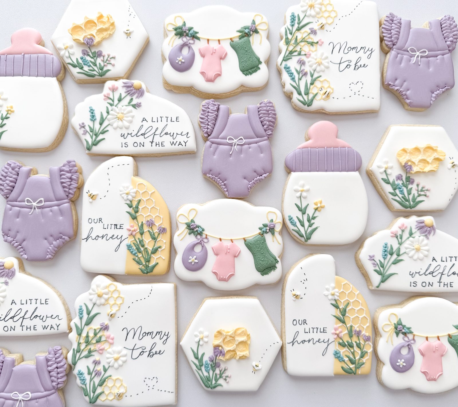 Mommy to Bee wildflower baby shower cookies with honeycomb, bees, lavender rompers, and bottles