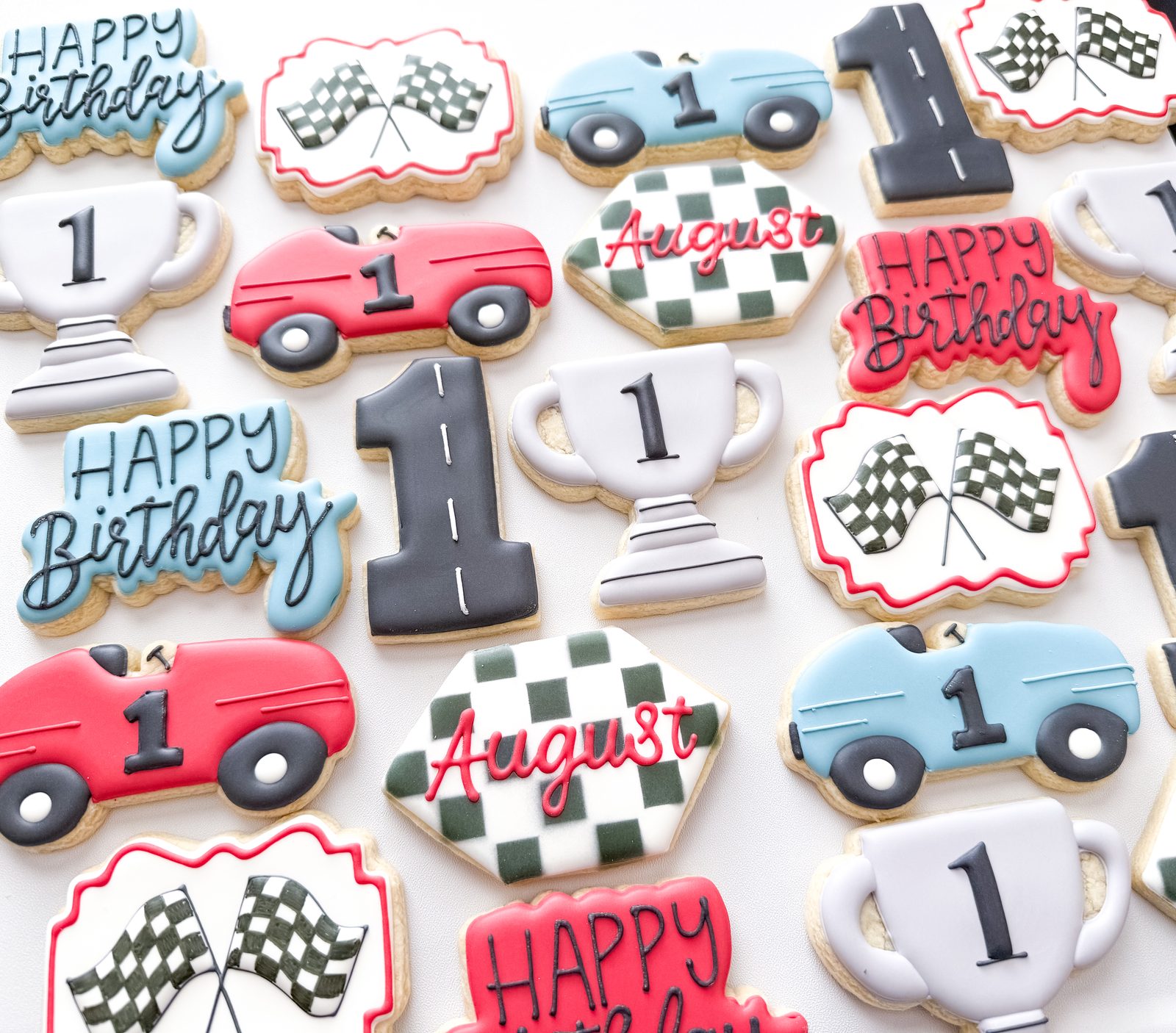 Vintage race car first birthday cookies with trophies, checkered flags, and custom name