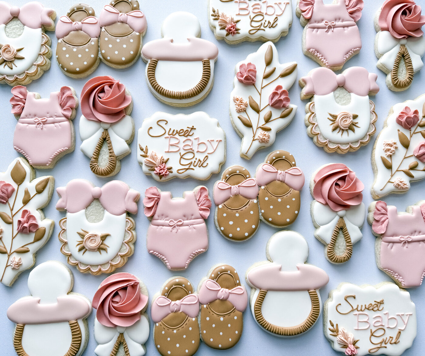 Sweet Baby Girl shower cookies with rosette rattles, booties, pacifiers, and florals in blush and tan