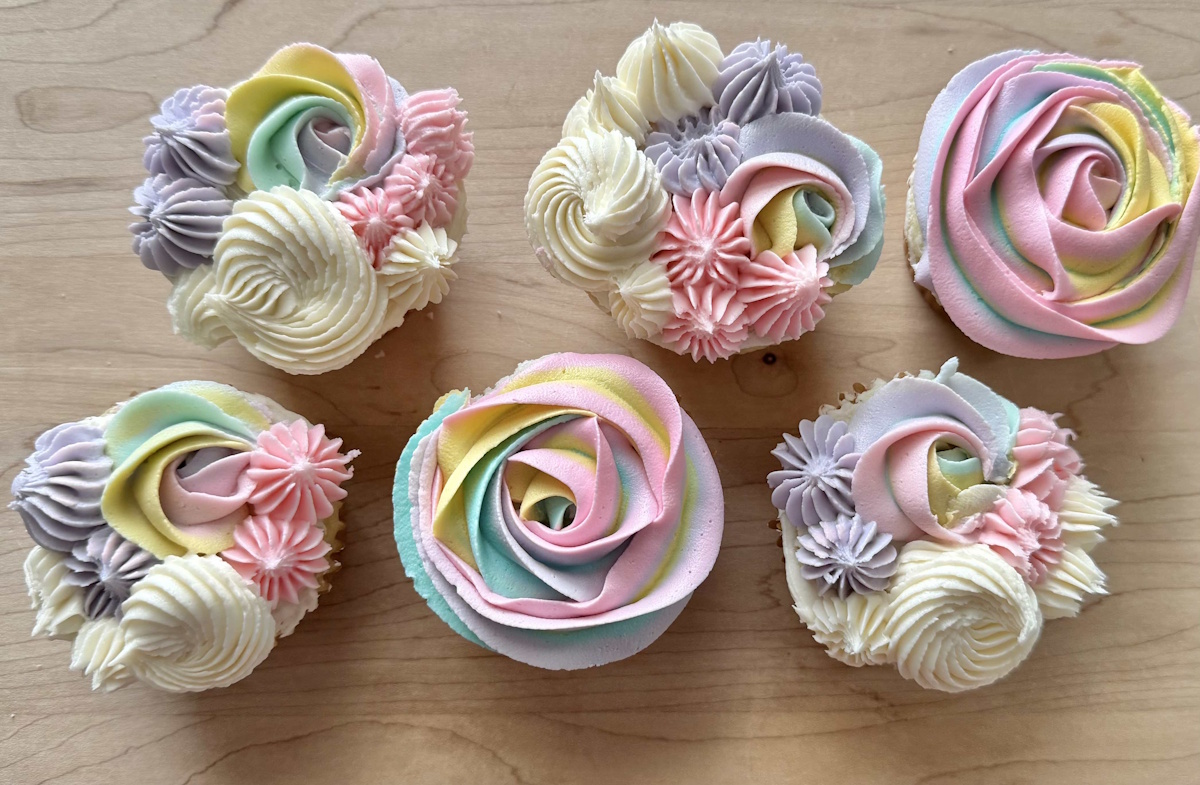 Pastel rainbow buttercream cupcakes with rosette swirls and mini flower clusters
